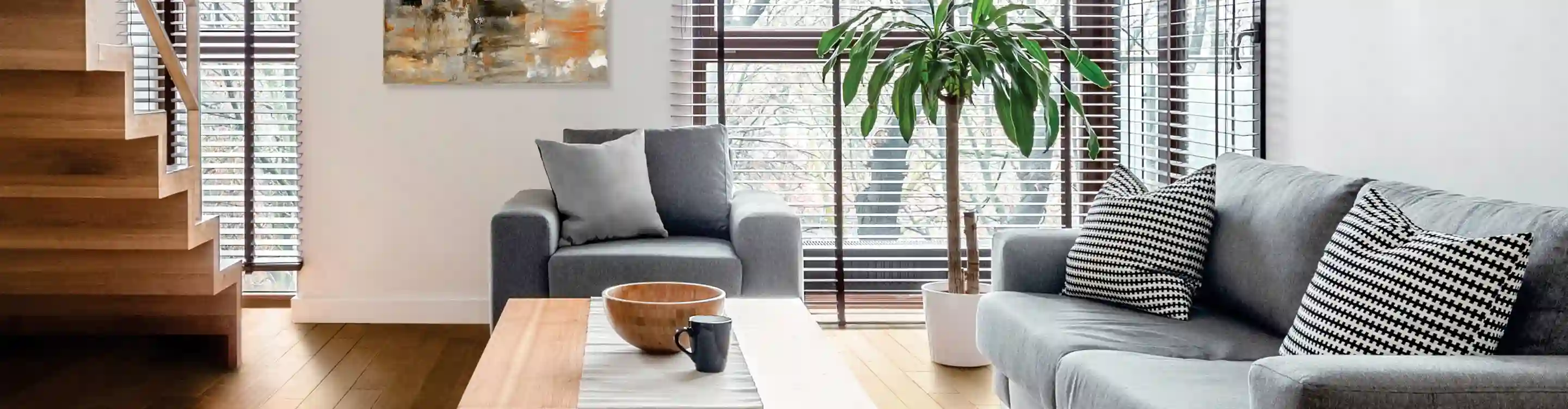 wood dark brown blinds in living room with light wood-look floors and grey armchair and sofa